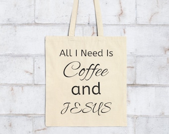 May include: A beige canvas tote bag with the text "ALL I NEED IS Coffee and JESUS" printed in black. The bag has two handles and is displayed against a white brick wall.