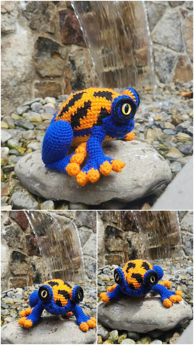 May include: A crocheted frog toy featuring a vibrant orange and black patterned back with a solid blue body, limbs, and head. The frog has large, prominent yellow eyes with black pupils and orange-tipped toes, crafted with detailed yarn stitching.