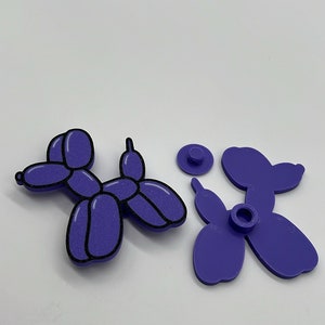 Pode incluir: Um animal de bal&atilde;o roxo em forma de c&atilde;o, desmontado em tr&ecirc;s pe&ccedil;as. O c&atilde;o &eacute; feito de um material texturizado e tem um contorno preto.