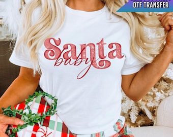 May include: White t-shirt with a red glitter design that says "Santa Baby".