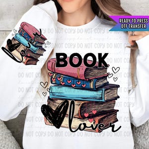 May include: A white sweatshirt with a design of a stack of books with hearts and the text "Book Lover" printed on it. The design is ready to press as a DTF transfer.