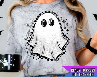 May include: Ready to press DTF transfer with a white ghost with big eyes and the text "hey boo" in a black and white checkered background.