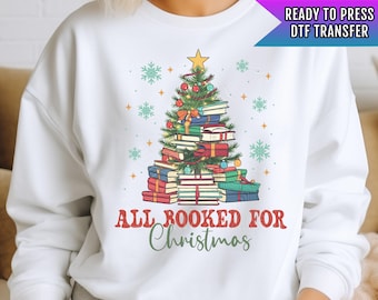 Könnte beinhalten: Weißer Pullover mit einem Weihnachtsbaum aus Büchern und dem Text "All Booked for Christmas".