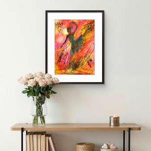 Peut inclure: Une peinture à l'aquarelle encadrée d'une ballerine en tutu vert, sur fond orange et jaune vif. Des traits noirs soulignent la danseuse et comprennent des contours d'instruments de musique. L'œuvre est exposée au-dessus d'une étagère en bois avec des livres, des fleurs et des objets décoratifs.