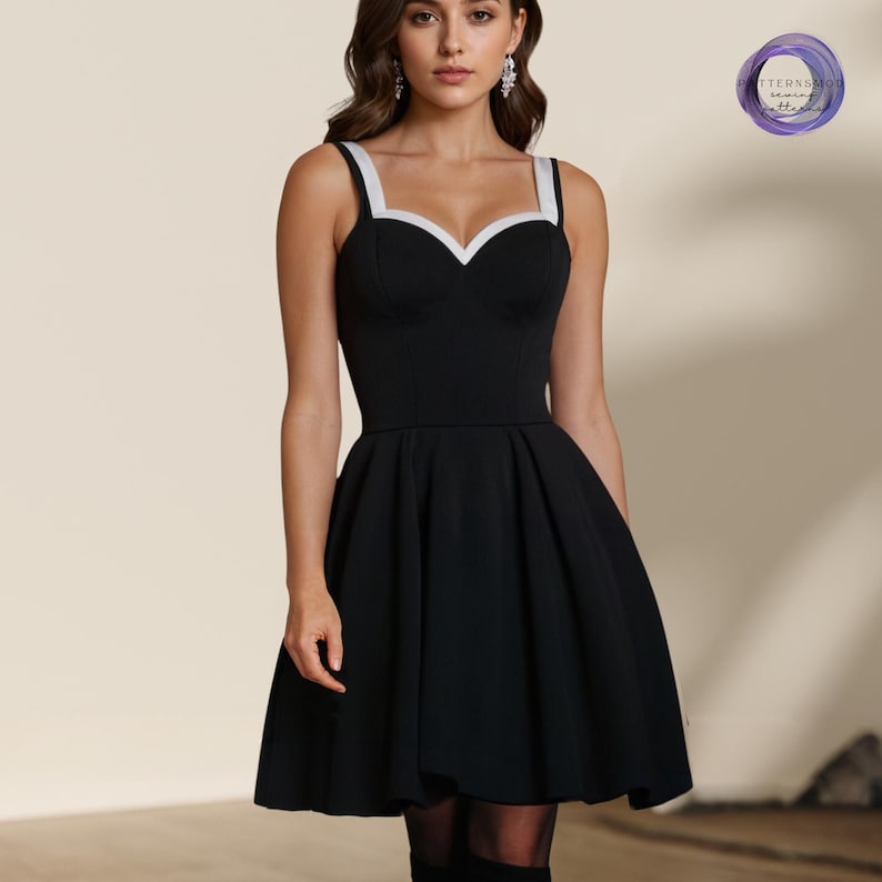 Peut inclure: Une robe patineuse noire avec une bordure blanche autour de l'encolure. La robe a une encolure en c&oelig;ur et un corsage ajust&eacute;. La jupe est ample et s'&eacute;vase &agrave; partir de la taille.