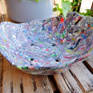 Może przedstawiać: Kolorowa, wielokolorowa miska z recyklingu z falistym brzegiem i otworami drenażowymi. Miska jest wykonana z recyklingu i ma unikalny marmurowy wygląd.