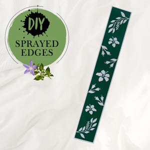 Peut inclure: Un pochoir vert avec un motif floral blanc. Le pochoir présente un motif répétitif de fleurs d'hibiscus et de feuilles. Le texte "DIY SPRAYED EDGES" est visible en arrière-plan.