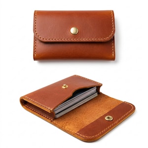 May include: Two views of a brown leather card holder. The top image shows the closed holder with a gold snap closure. The bottom image shows the holder open, revealing a stack of cards. The leather is stitched with a contrasting thread.