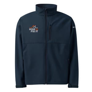 May include: Navy blue softshell jacket with a full-length zipper and a stand-up collar. The jacket features the text "JOSE CAN FIX IT" in white and orange above the left chest. A small logo is on the right sleeve.