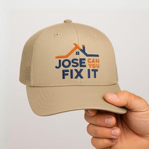 May include: Tan trucker hat with a mesh back and a curved brim. The front of the hat features the text "JOSE CAN YOU FIX IT" in blue and orange, with a house graphic above the text.