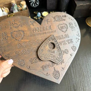 Tavola Ouija a forma di cuore con planchette: tavola parlante romantica e stregata
