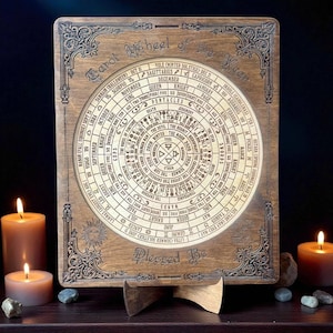 Może przedstawiać: Drewniane Koło Roku Tarota z misternymi grawerunkami. Okrągły wz&oacute;r zawiera symbole astrologiczne, daty i tekst, w tym "Blessed Be". Element jest prezentowany na drewnianym stojaku, z zapalonymi świecami i kamieniami na pierwszym planie.