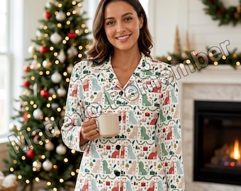 Könnte beinhalten: Ein langärmeliges, geknöpftes Pyjama-Oberteil mit einem sich wiederholenden Muster aus Hunden, Weihnachtsgeschenken und festlichen Girlanden in Rot-, Grün- und Blautönen auf weißem Grund. Das Hemd hat einen Reverskragen und dunkle Knöpfe.
