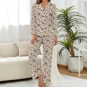 May include: Beige pajama set with a repeating pattern of dogs, gifts, and Christmas decorations. The long-sleeved top has a button-down front and a notched collar. The pants are straight-legged. The pajamas are made of a soft, comfortable material.