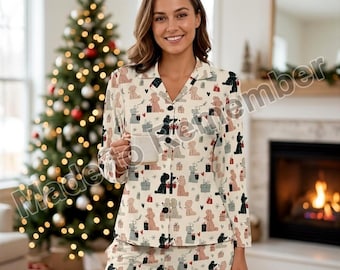 Könnte beinhalten: Ein langärmeliges, durchgeknöpftes Pyjama-Oberteil und eine passende Hose aus cremefarbenem Stoff mit einem sich wiederholenden Muster aus schwarzen, beigen und grauen Pudeln, Geschenkpaketen und kleinen schwarzen Herzen, mit dunklen Knöpfen.