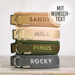 Op de afbeelding: Een stapel van vier hondenhalsbanden in bruin, beige, olijfgroen en donkergrijs. Elke halsband heeft een mesh-textuur, een metalen D-ring, een zwarte plastic gesp en een label met CANICLIX. De namen SANDRO, MILA, PINUS en ROCKY zijn geborduurd.
