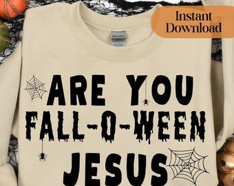 Könnte beinhalten: Ein beigefarbenes Sweatshirt mit Rundhalsausschnitt und dem schwarzen Schriftzug ARE YOU FALL-O-WEEN JESUS. Das Design enthält schwarze Spinnennetz-Illustrationen und kleine Spinnengrafiken, die in den Schriftzug integriert sind.