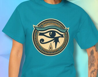 May include: A turquoise blue t-shirt with a graphic of the Eye of Horus in a circular frame with gold and blue accents.