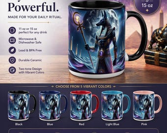 May include: A ceramic mug with a black handle and rim, featuring an Anubis design against a moonlit background. The mug is available in 11 or 15 oz sizes and comes in various colors, including black, blue, red, light blue, and pink. Text on the mug reads "Mystical. Powerful."
