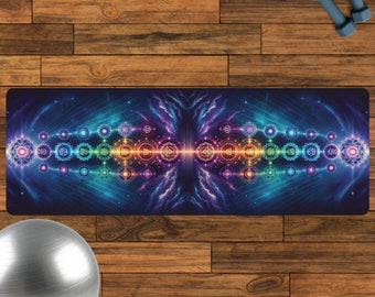 Puede incluir: Una esterilla de yoga con un diseño colorido que presenta un sistema de chakras con símbolos y patrones geométricos. La esterilla tiene un fondo azul oscuro con nubes moradas y rosadas.