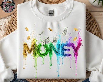 May include: White sweatshirt featuring the word "MONEY" in a vibrant, dripping paint design. The graphic includes gold coins and dollar bills, with colours ranging from yellow to pink.