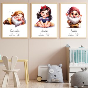 Puede incluir: Tres impresiones enmarcadas con ilustraciones de personajes de dibujos animados del cuento de hadas Blancanieves. Cada impresión presenta un enano diferente, con su nombre y fecha de nacimiento. Los enanos son Dormilón, Amelie y Sabio.