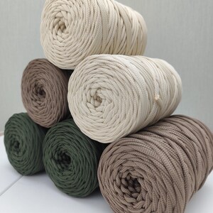 Op de afbeelding: Een set van drie keramische mokken met een gespikkelde, matte afwerking. De mokken zijn in de kleuren cr&egrave;me, lichtgrijs en donkergrijs. Elke mok heeft een eenvoudig, minimalistisch ontwerp en een afgeronde handgreep.