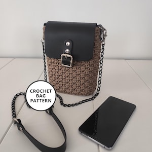 May include: A brown crochet bag with a black leather flap and strap. The bag has a silver chain strap and buckle closure. A smartphone is next to the bag. The image includes the text "CROCHET BAG PATTERN".