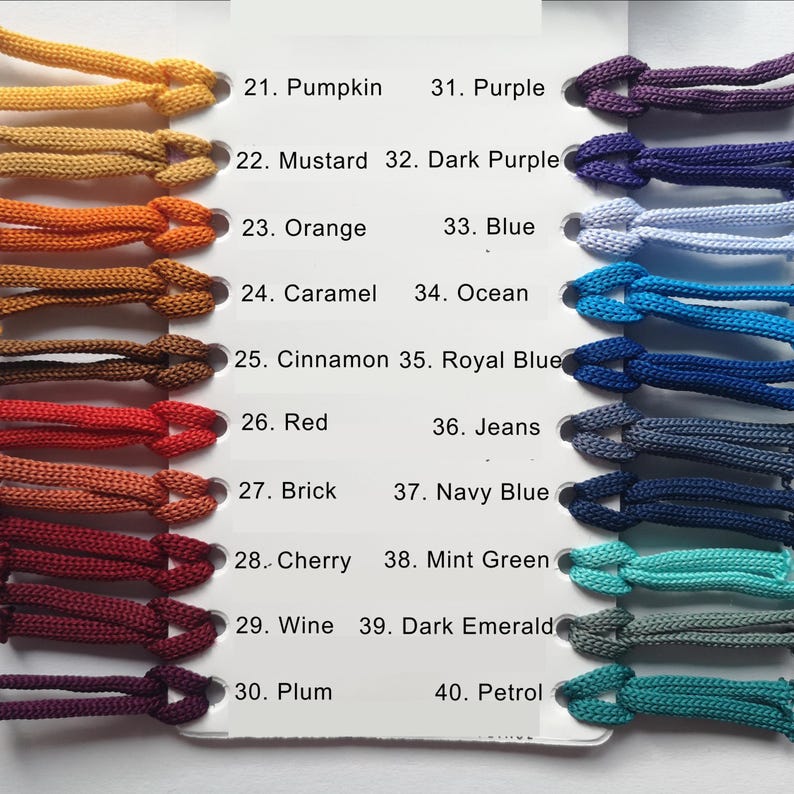 Op de afbeelding: Een kleurenkaart met een verscheidenheid aan koordkleuren, waaronder Pompoen, Mosterd, Oranje, Karamel, Kaneel, Rood, Baksteen, Kers, Wijn en Pruim. Extra kleuren zijn Paars, Donkerpaars, Blauw, Oceaan, Koningsblauw, Jeans, Marineblauw, Mintgroen, Donkergroen en Petrol.