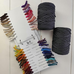 Könnte beinhalten: Draufsicht auf eine Farbkarte und zwei Spulen graues Garn. Die Karte zeigt eine Reihe von Farben, darunter Kürbis, Senf und Rot. Der Text "BAGS BY MONKA" ist auf der Karte zu sehen.