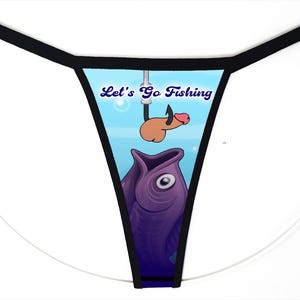 May include: A thong with black trim featuring a graphic print of a purple fish with its mouth open, looking up at a fishing hook with a phallic-shaped bait attached. The text Let's Go Fishing is printed in blue above the hook on a light blue background.