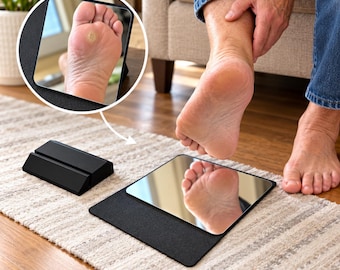 May include: A square, reflective floor mirror with a black base, designed for viewing the sole of the foot. The mirror is positioned flat on the ground, allowing a clear reflection of the foot's underside for inspection and care.