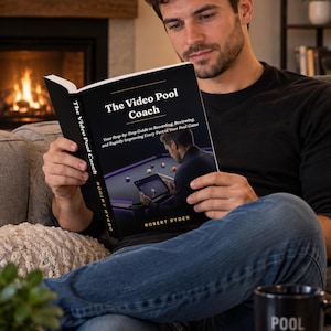 May include: A paperback book titled The Video Pool Coach by Robert Ryder with a black cover featuring an image of a person using a tablet at a pool table. The subtitle reads Your Step-by-Step Guide to Recording, Reviewing, and Rapidly Improving.