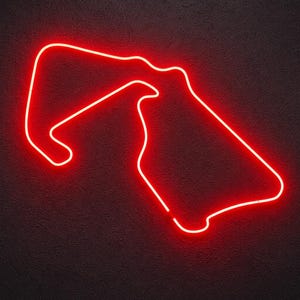 Könnte beinhalten: Ein leuchtend rotes Neonlicht in Form eines Rennstreckenverlaufs. Die leuchtenden roten Röhren bilden einen durchgehenden, komplexen Pfad mit scharfen Kurven und langen Geraden vor einem dunklen, strukturierten Hintergrund, der das Licht hervorhebt.
