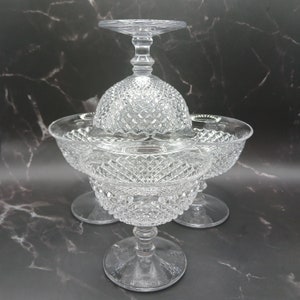 Könnte beinhalten: Drei klare Glasschalen für Desserts mit einem Diamantenmuster. Die Schalen sind übereinander gestapelt.