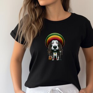 May include: A black t-shirt featuring a cartoon dog wearing a red, yellow and green hat and dreadlocks. The dog is holding a microphone and a guitar.