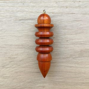 Hathor inspired pendulum in chakte viga wood, 8.7x2.3 centimeters, weight 20 grams