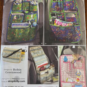 May include: Simplicity pattern 2916 featuring various car organizer designs. The patterns include seat-back organizers with multiple pockets, a shoulder bag, and a small tote bag. The organizers have different patterns and colors.