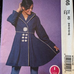 Puede incluir: Patrón de costura McCall's M7666, que presenta un abrigo azul marino con falda acampanada y botones decorativos. El patrón incluye tallas A5 (6-8-10-12-14). El abrigo tiene ribete blanco y un diseño de botones único.