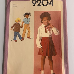 Puede incluir: Patrón de costura Simplicity vintage 9204 para un atuendo infantil. El patrón presenta ilustraciones de niños con varios atuendos, incluyendo una falda plisada, blusa y chaqueta. El patrón es talla 4.