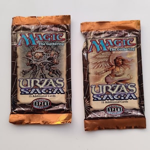 Può includere: Due bustine sigillate di Magic: The Gathering Urza's Saga con bordi in lamina color rame. Ogni bustina presenta il logo del gioco, il testo 15 Additional Cards e un sigillo Expert Level. Una bustina mostra una creatura meccanica, l'altra un angelo.