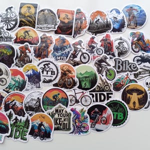 Puede incluir: Una colección de pegatinas con temática de bicicleta de montaña. Las pegatinas presentan varios diseños, incluyendo ciclistas en paisajes montañosos, texto como "Ride Bike" y las letras "MTB". La paleta de colores incluye naranja, azul, verde y negro.