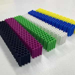 May include: Six honeycomb-shaped plastic spacers in black, magenta, green, white, blue, and yellow.