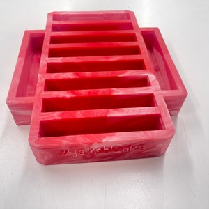 May include: Red silicone mold with eight rectangular cavities and a single larger rectangular cavity. The mold has a white marbled pattern and the text "#Jakeblanks" is embossed on the bottom.