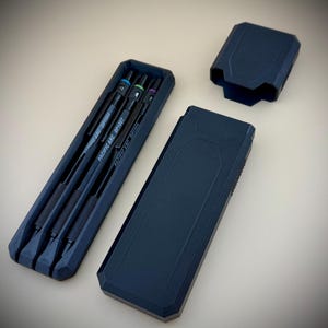 May include: A set of four black precision screwdrivers with colored tips and the text "PACIFIC ARG DP1006" and "PACIFIC ARG DP1007" in a dark blue case. The case is open, revealing the tools, and the lid is separate.