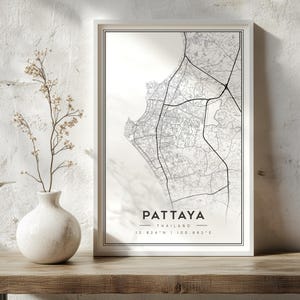 May include: A framed vertical wall art print featuring a black and white street map of Pattaya, Thailand. The print includes the text PATTAYA, THAILAND, and the coordinates 12.924 N | 100.882 E centred at the bottom within a thin black border.