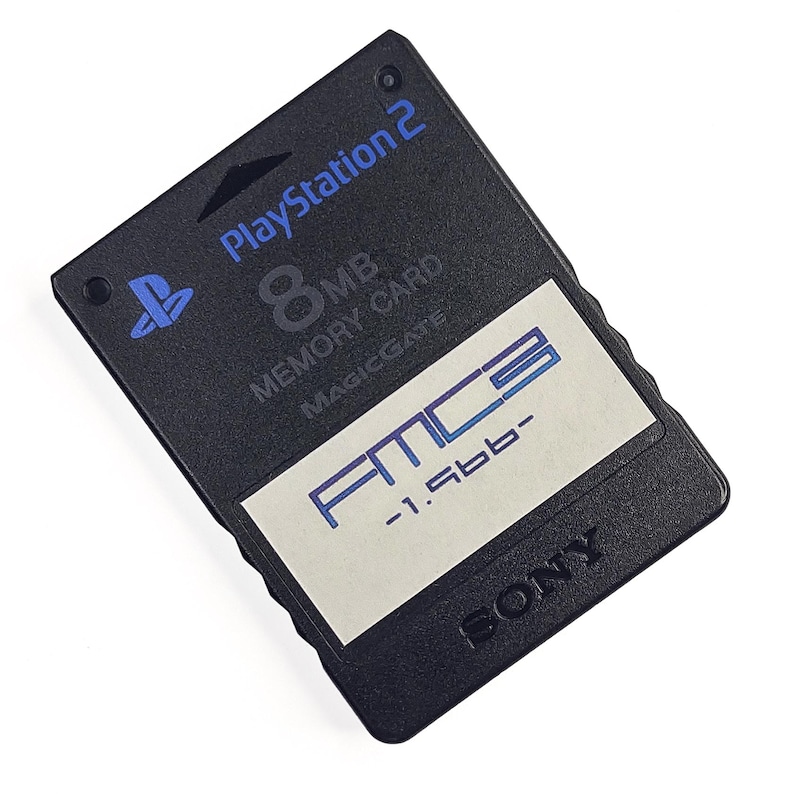 May include: Black PlayStation 2 8MB Memory Card with the PlayStation logo and the text "PlayStation 2". The card has a white sticker with blue text that reads "FMCB -1.5bb-" and the Sony logo.