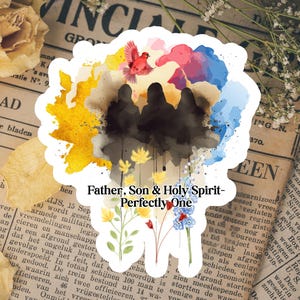 May include: A sticker with a watercolor design featuring three dark silhouettes, a red bird, and colorful clouds. The text "Father, Son & Holy Spirit - Perfectly One" is included. Floral elements are at the bottom, set against a vintage newspaper background.