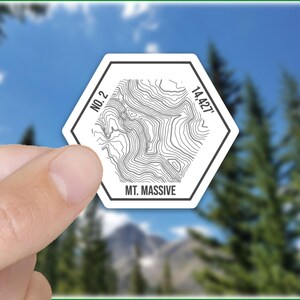 May include: White hexagonal sticker with a topographic map design of Mt. Massive, Colorado. The sticker includes the text "No. 2" and "14,427'" and the words "Mt. Massive".