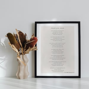 Puede incluir: Una impresi&oacute;n enmarcada en negro con un poema titulado "thank you, mum" sobre un fondo blanco. El poema trata sobre el amor y la apreciaci&oacute;n por una madre. La impresi&oacute;n est&aacute; sobre una superficie blanca junto a un jarr&oacute;n con flores secas.